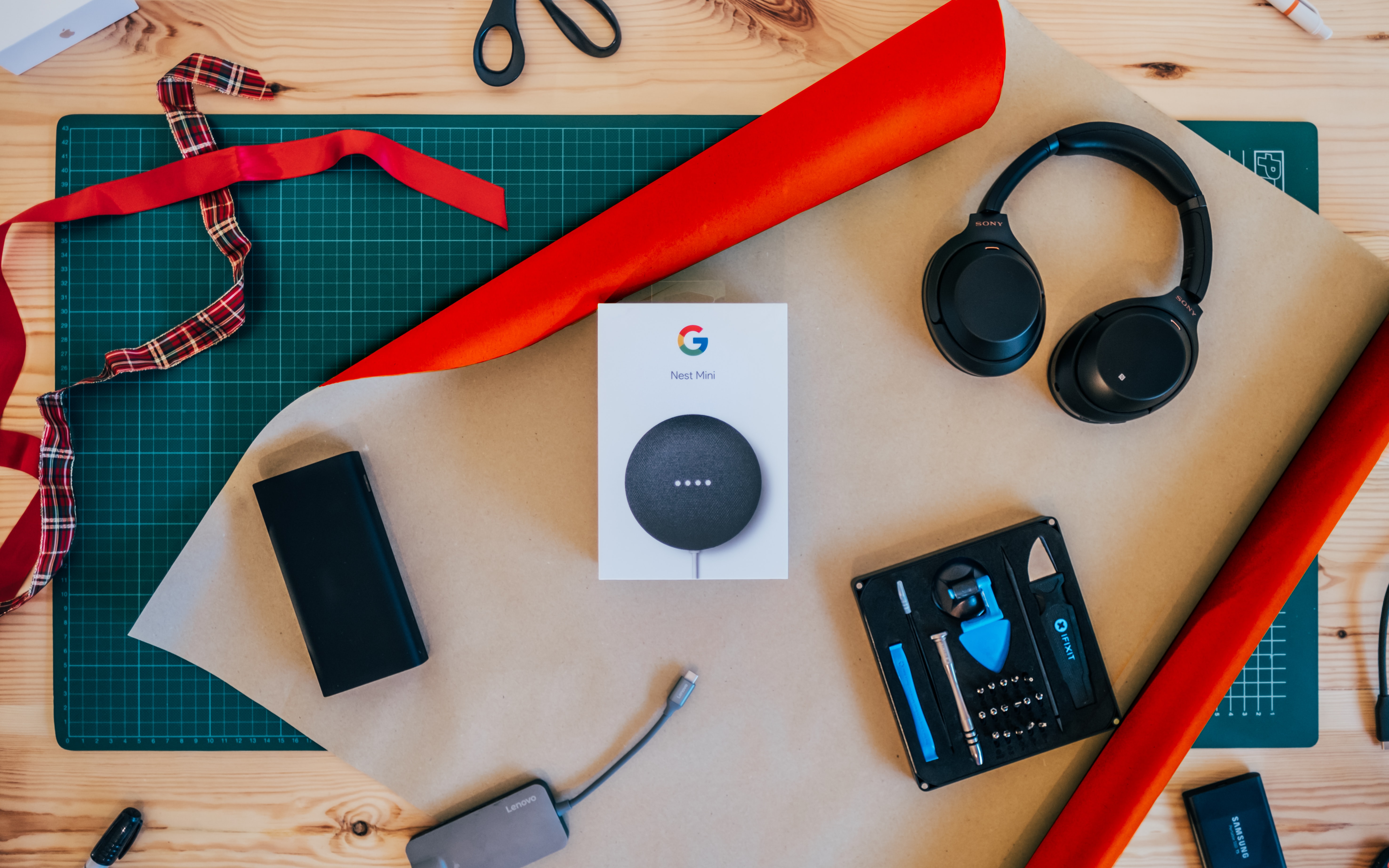 Google mini on a table surrounded by different electronics