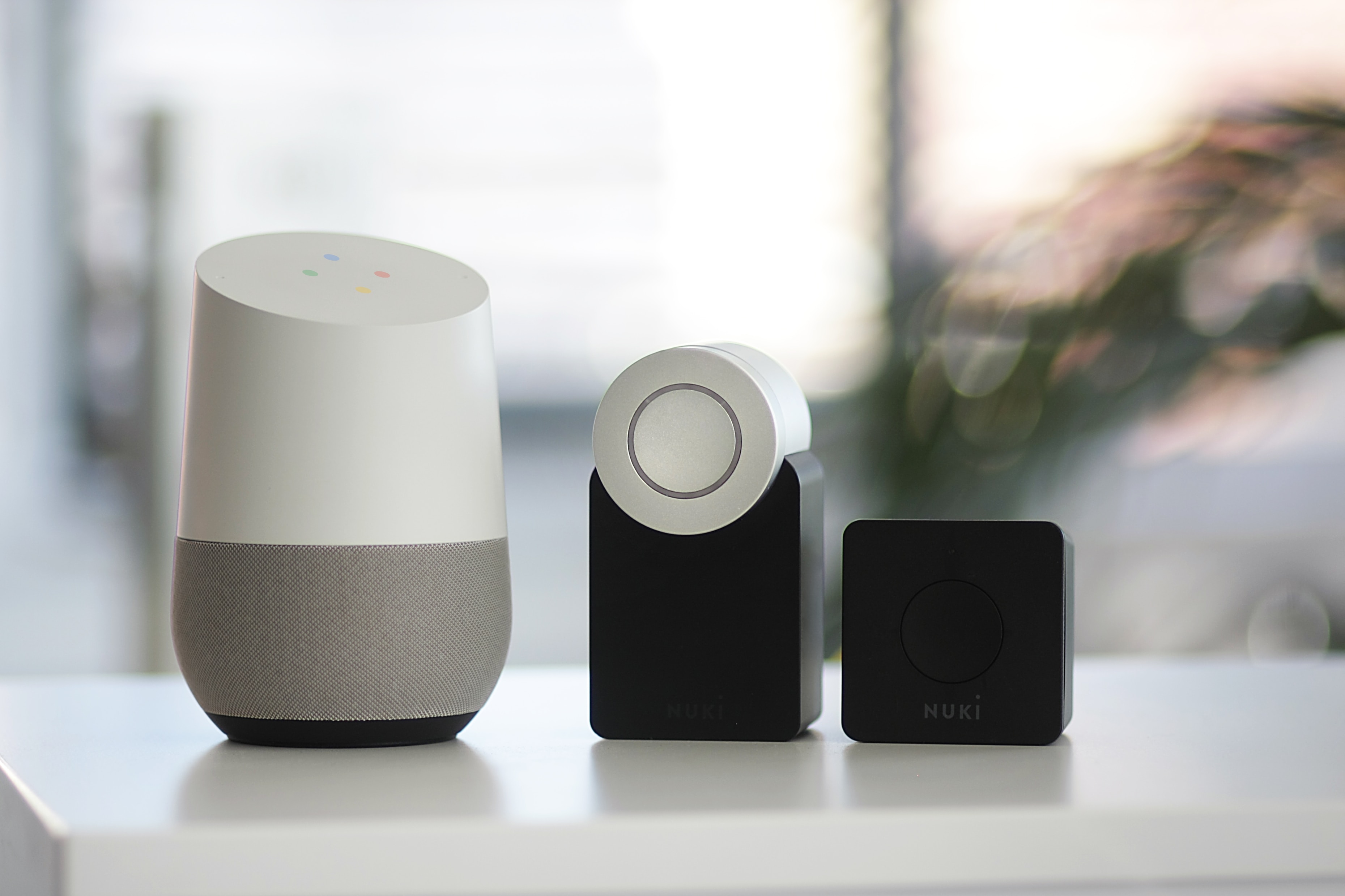 google home on a table next to speakers